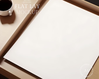 May include: A white sheet of paper on a wooden tray. The paper is blank and ready for a flat lay mockup. The text "STUDIO DYNAMIC FLAT LAY MOCKUP" is visible in the top left corner of the image.