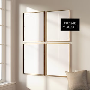 May include: Four gold-framed square picture frames are hung on a white wall. The frames are empty and ready for artwork. The frames are arranged in a two by two grid.