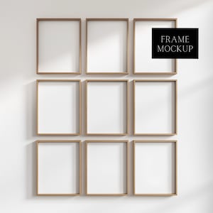 May include: A wall with nine empty picture frames, all the same size and shape. The frames are made of a light brown wood and have a simple, modern design. The frames are arranged in a grid pattern, with three rows of three frames each. The frames are all empty, ready to be filled with photos or artwork. FRAME MOCKUP is written in black text on a white background.