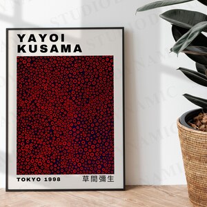May include: A black and white poster with the text "YAYOI KUSAMA" in bold black letters. The poster features a red and black abstract pattern of circles. The text "TOKYO 1998" and "草間彌生" are at the bottom of the poster.