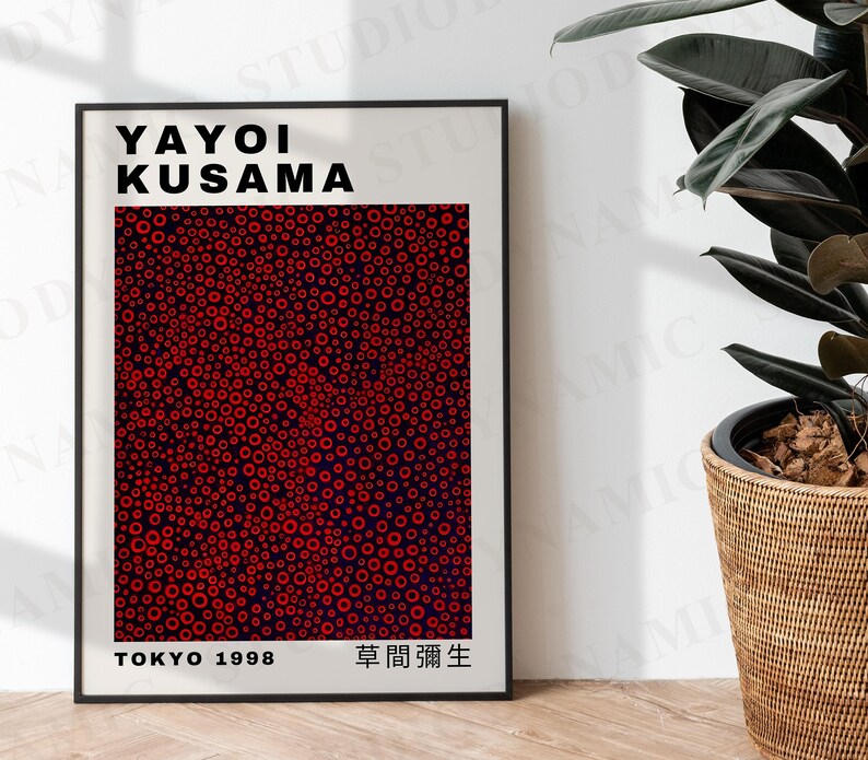 May include: A black and white poster with the text "YAYOI KUSAMA" in bold black letters. The poster features a red and black abstract pattern of circles. The text "TOKYO 1998" and "草間彌生" are at the bottom of the poster.