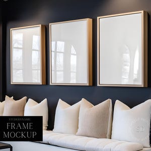 May include: Three gold framed pictures hanging on a dark blue wall above a white couch with beige pillows. The text "Studiodynamic Frame Mockup" is in the lower left corner of the image.