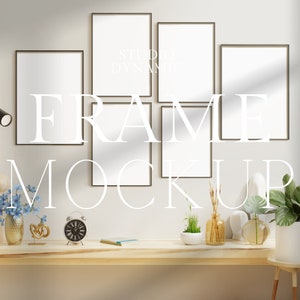 May include: Five black picture frames with white mats are arranged in a grid on a white wall. The frames are empty and ready for photos or artwork. The frames are in a living room setting with a wooden table, a lamp, and plants.