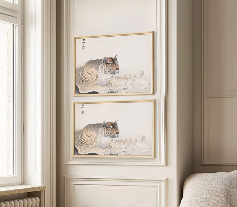 May include: Two framed prints of a tiger lying down. The tiger is brown and black with white stripes. The prints are in a gold frame and have a white background.