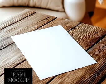 May include: A white sheet of paper sits on a wooden table. The paper is blank and ready for writing or drawing. The table is made of rustic wood planks.