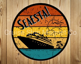 May include: A round, vintage-style magnet with a sunset background and a cruise ship silhouette. The text "SEAESTA!" is written in blue letters on the magnet.