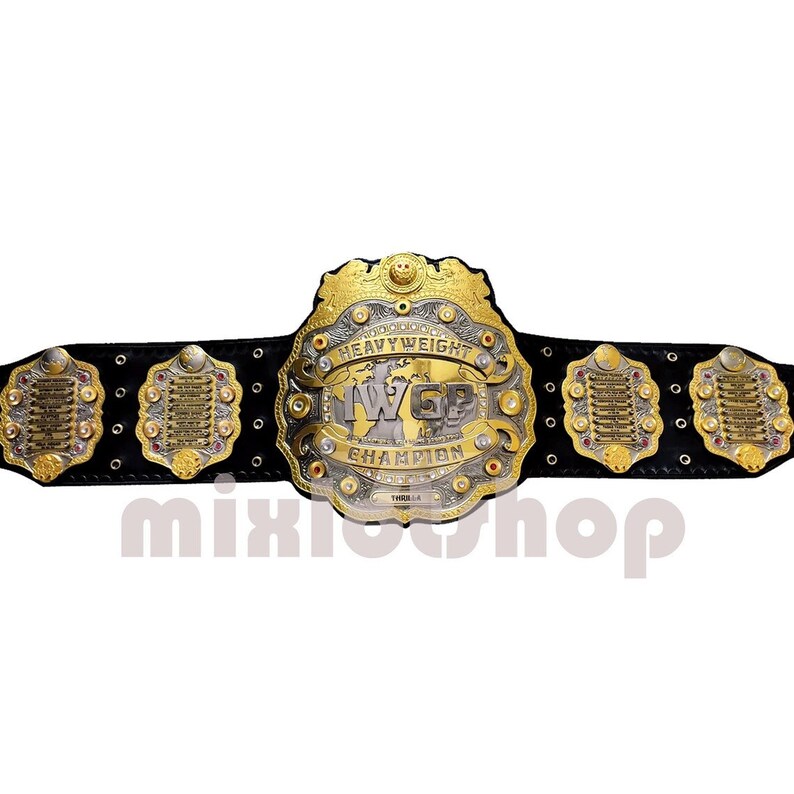May include: A gold and silver championship belt with the text "HEAVYWEIGHT CHAMPION" and "IWGP" on the front. The belt has a black leather strap and several gold and silver decorative plates. The image also includes the text "mixioshop".