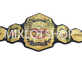May include: A gold and black wrestling championship belt with intricate detailing. The belt features the text "WORLD CHAMPION" and "NWA" in a bold font. The design includes decorative elements and a central emblem.