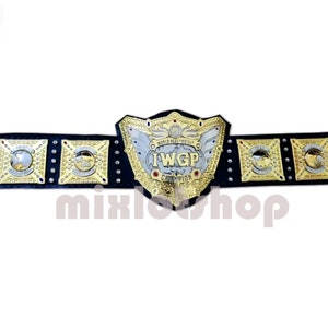 Könnte beinhalten: Ein gold-silberner IWGP World Heavyweight Championship Gürtel. Der Gürtel hat eine große Mittelplatte mit dem Text "IWGP Champion" und kleinere Platten mit goldenen Akzenten. Der Gürtel ist schwarz.
