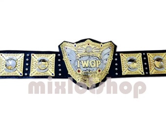 May include: A gold and silver IWGP World Heavyweight Championship belt. The belt features a large central plate with the text "IWGP Champion" and smaller plates with gold accents. The belt is black.