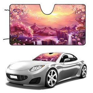 May include: A pink and purple car sunshade with a scenic landscape featuring a waterfall, mountains, and cherry blossoms. The sunshade is designed to fit most car windshields.