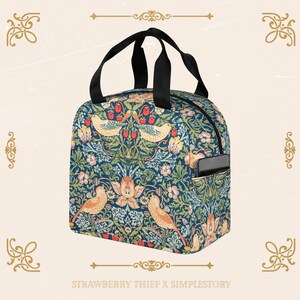 Peut inclure: Un sac &agrave; d&eacute;jeuner bleu et vert avec un motif floral repr&eacute;sentant des oiseaux et des fraises. Le sac a une poign&eacute;e noire et une fermeture &agrave; glissi&egrave;re. Le sac a une petite poche lat&eacute;rale pour un t&eacute;l&eacute;phone. Le sac porte l'inscription "STRAWBERRY THIEF X SIMPLESTORY" en bas.