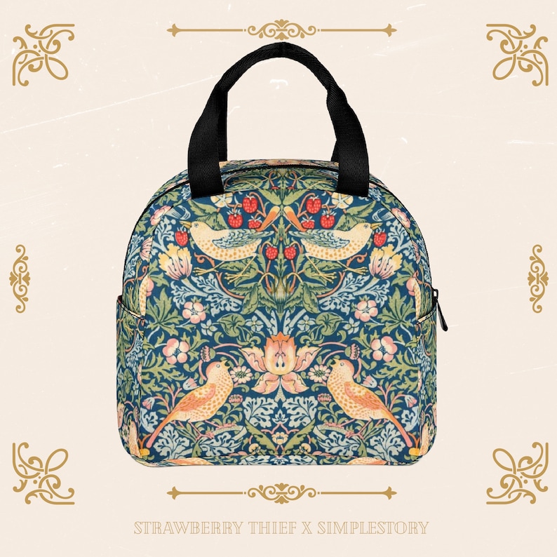 Peut inclure: Un sac &agrave; d&eacute;jeuner isotherme bleu et vert avec un motif floral repr&eacute;sentant des oiseaux et des fraises. Le sac a une poign&eacute;e noire et une fermeture &eacute;clair. Le texte "STRAWBERRY THIEF X SIMPLESTORY" est imprim&eacute; en bas de l'image.