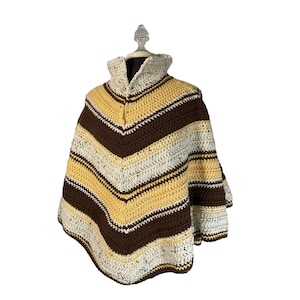 May include: A brown, white, and yellow striped crocheted poncho with a high collar.