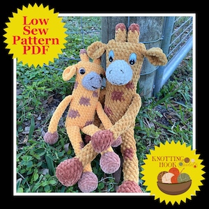May include: Two crocheted giraffe plushies, one larger than the other, are sitting together on a bed of green grass. The giraffes are both brown and yellow with a star pattern. The larger giraffe has a brown nose and brown eyes. The smaller giraffe has a brown nose and black eyes. The giraffes are sitting next to a wooden post with a metal fence behind it. The text "Knotting Hook Crochet" is visible in the lower right corner of the image.