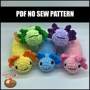 Peut inclure: Cinq peluches axolotl crochet&eacute;es dans diff&eacute;rentes couleurs&nbsp;: jaune, vert, bleu, violet et rose.  PDF NO SEW PATTERN est &eacute;crit en texte noir sur fond noir.