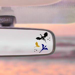 May include: Three dragon decals in black, gold, and blue are displayed on a car's rearview mirror. The decals are accompanied by small star accents. The text "Little Decal Market" and "little moments of joy" are at the bottom.