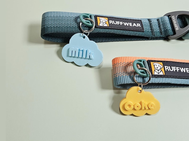 Pu&ograve; includere: Due collari per cani con targhette a forma di nuvola. Una targhetta &egrave; azzurra e dice "milk", l'altra &egrave; gialla e dice "coke". I collari sono verde acqua e arancioni con il logo "Ruffwear".