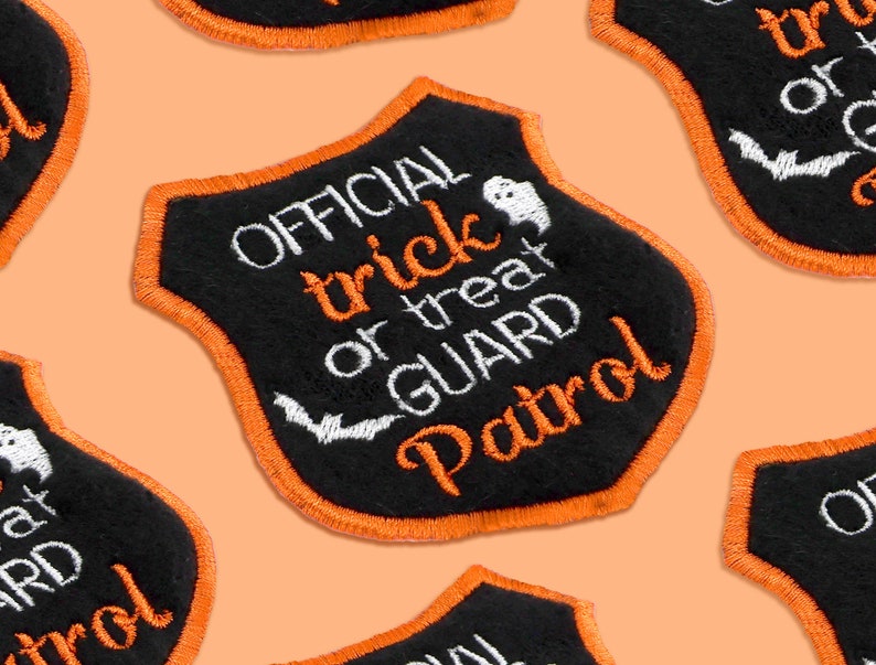 May include: Black felt patch with orange stitching shaped like a shield. It says "OFFICIAL trick or treat GUARD Patrol" in white embroidery with a ghost and bat graphic.