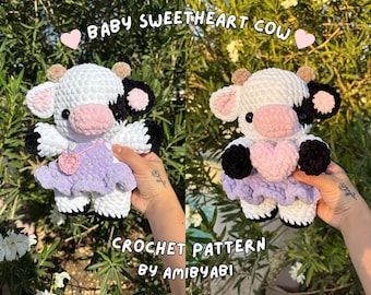 May include: Two crochet cow plushies, one in each hand, against a backdrop of greenery. The cows are white with black spots, pink noses, and small horns. They wear lavender dresses and have the text "Baby Sweetheart Cow" and "Crochet Pattern by AmiByAbi".