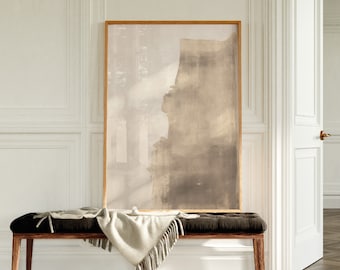May include: A brown and beige abstract painting in a wooden frame hangs above a dark brown bench with a white throw blanket draped over it.