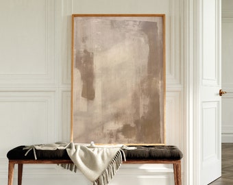 May include: A brown wooden bench with a white throw blanket draped over it. The bench is in front of a white wall with a framed abstract painting in muted tones of brown and beige.