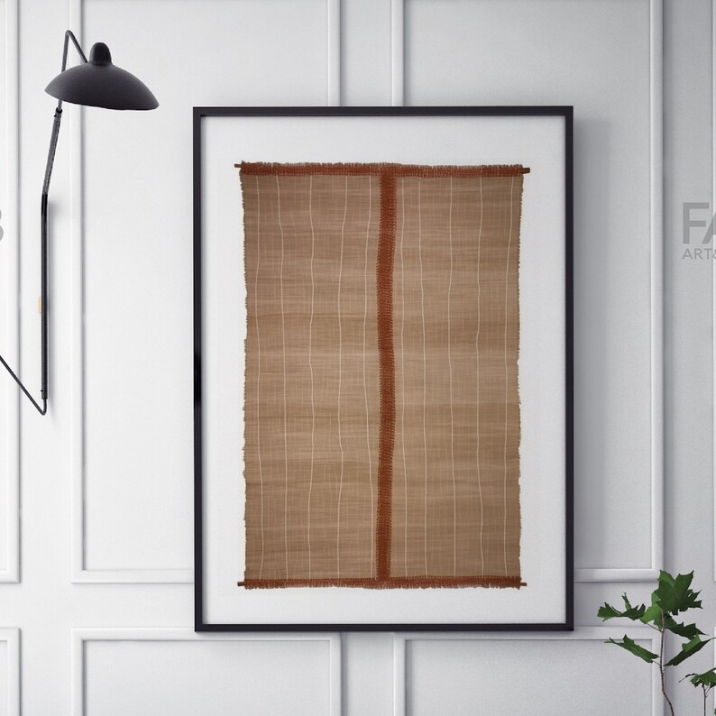May include: A framed wall hanging with a woven texture in shades of brown and white. The woven piece has a vertical red stripe down the center.