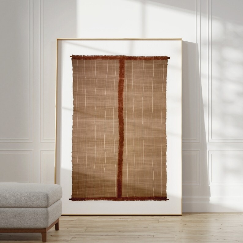 May include: A framed wall tapestry with a brown and white woven pattern and a red border. The tapestry has a fringed edge.