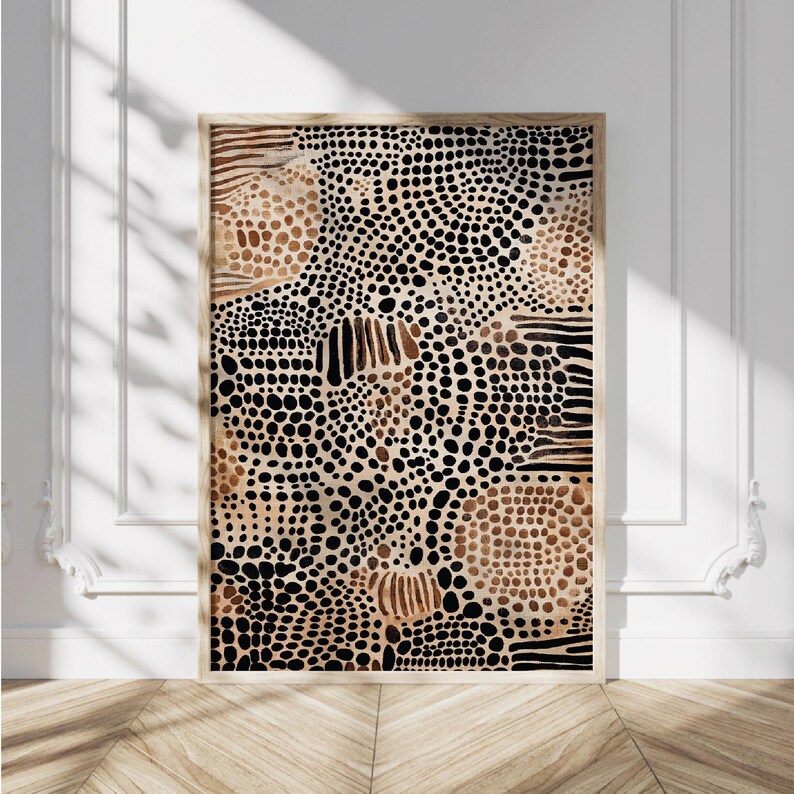 K&ouml;nnte beinhalten: Abstrakter Kunstdruck mit einem braunen, schwarzen und wei&szlig;en Muster aus Punkten und Linien. Der Druck ist in einem naturfarbenen Holzrahmen gerahmt.
