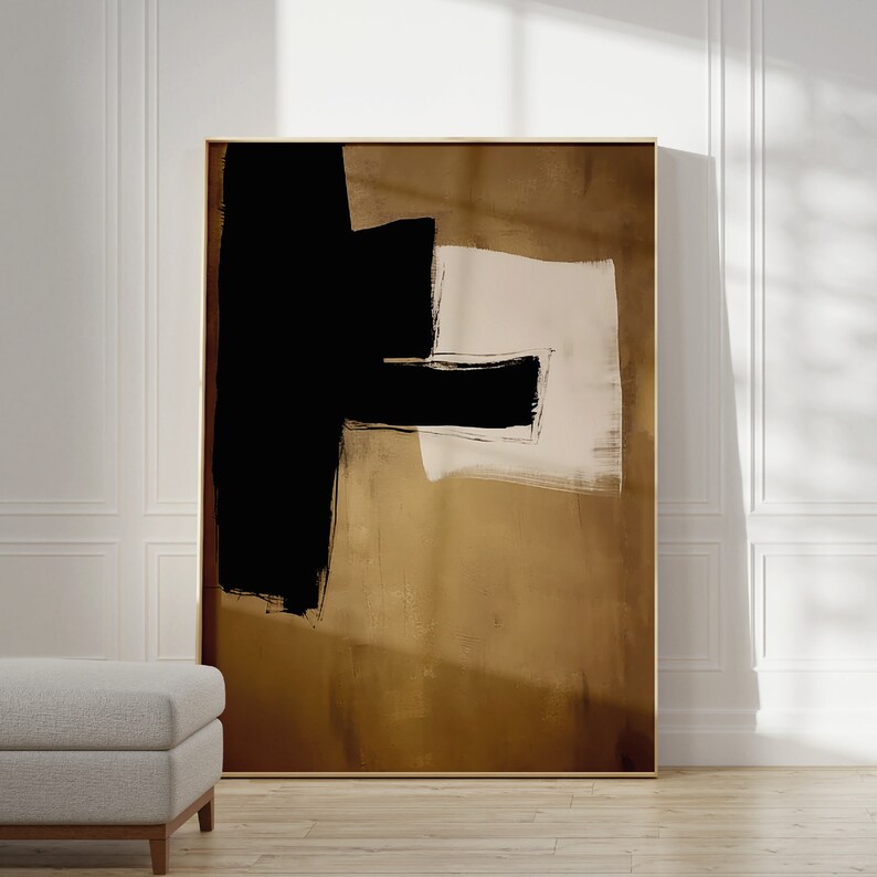 May include: Abstract art print with black and white brushstrokes on a brown background. The print is framed in a gold frame.
