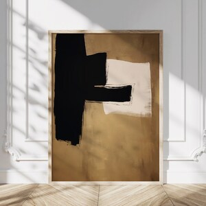 May include: Abstract art print with black and brown brushstrokes on a beige background. The print is framed in a light wood frame.