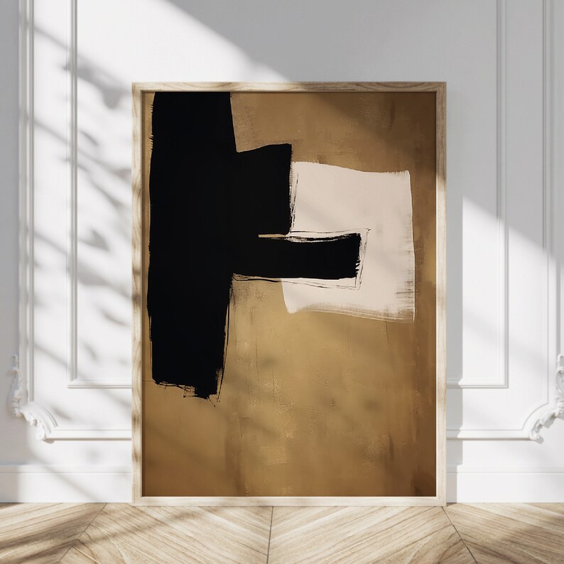 May include: Abstract art print with black and brown brushstrokes on a beige background. The print is framed in a light wood frame.