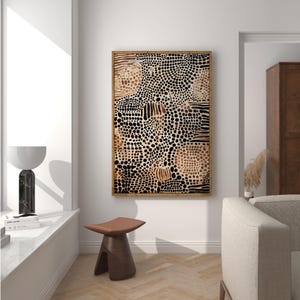 K&ouml;nnte beinhalten: Abstrakter Kunstdruck mit einem braunen, schwarzen und wei&szlig;en Muster aus Punkten und Linien. Der Druck ist in einem hellen Holzrahmen gerahmt und h&auml;ngt an einer wei&szlig;en Wand.