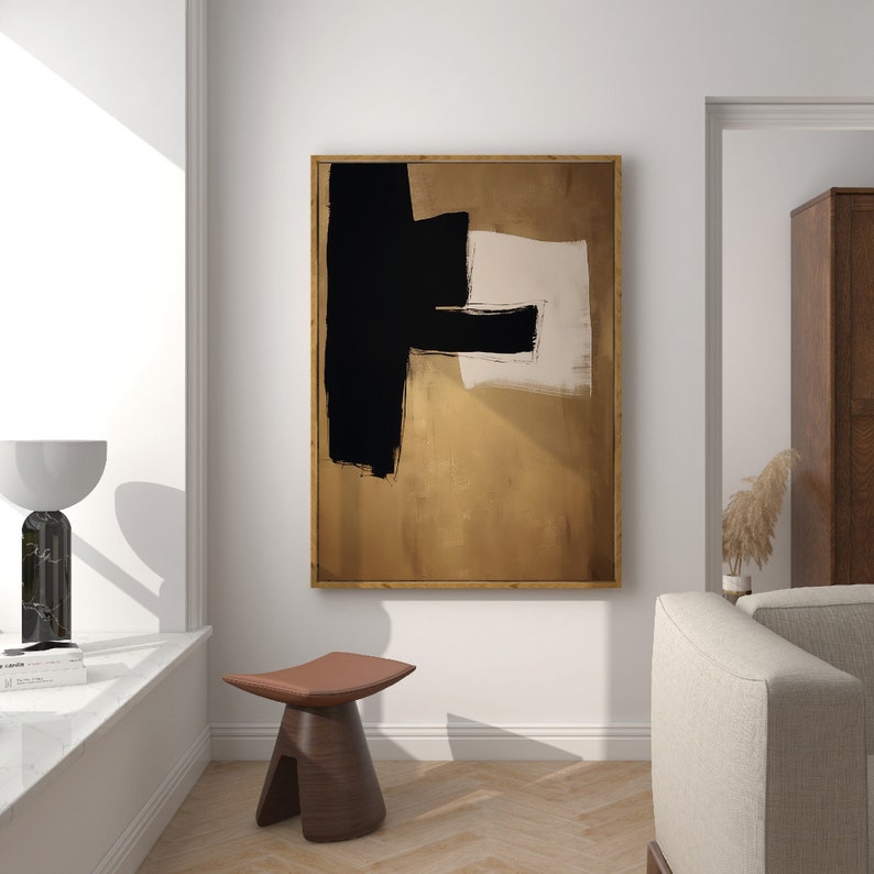 May include: Abstract art print with black and white brushstrokes on a gold background. The print is framed in a wooden frame.