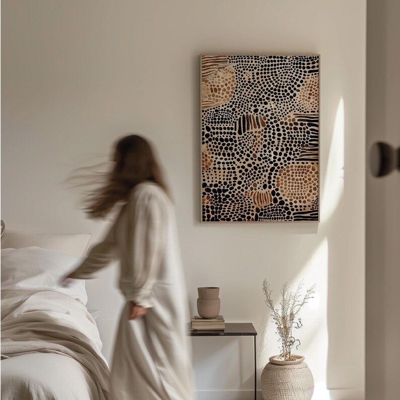 K&ouml;nnte beinhalten: Ein abstrakter Kunstdruck in Schwarz und Braun mit einem Muster aus Punkten und Linien. Der Druck h&auml;ngt an einer wei&szlig;en Wand in einem Schlafzimmer mit einem Bett und einem Nachttisch.