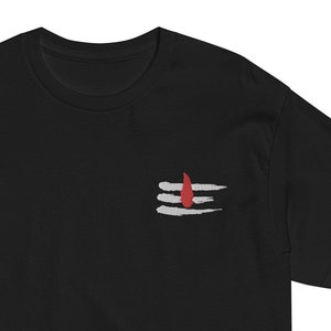 May include: Black t-shirt with a white and red embroidered symbol, a stylized representation of the Hindu god Shiva's trident.