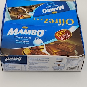 May include: A blue Mambo milk chocolate box with the words "Chocolat Au Lait" and "Milk Chocolate" printed on the front. The box also features images of chocolate and the words "100% Pur beurre de Cacao."
