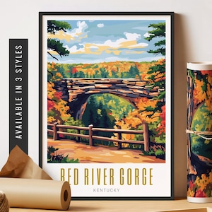 May include: A framed art print of Red River Gorge, Kentucky, showing a stone bridge over a gorge with autumn foliage. The print is in a black frame and is displayed with a rolled-up print and other art supplies.