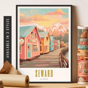 May include: A framed art print featuring a colorful illustration of Seward, Alaska. The artwork depicts a row of vibrant buildings along a boardwalk, with mountains and a sunset in the background. The text "SEWARD ALASKA" is at the bottom. Available in 3 styles.