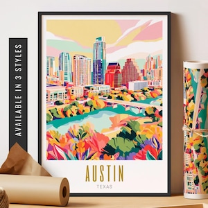 May include: A framed art print of the Austin, Texas skyline in a colorful, stylized illustration. The print features the city's buildings, a river, and a bridge, with the word "AUSTIN" in gold lettering. The words "AVAILABLE IN 3 STYLES" are printed on the side.