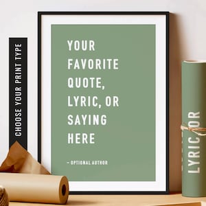 May include: A framed print with a sage green background and white text that reads "Your favourite quote, lyric, or saying here - Optional Author".