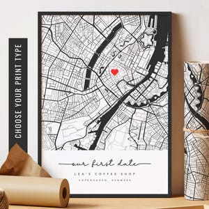 May include: Black and white map print with a red heart marking a location. The text below the map reads "our first date", "LEA'S COFFEE SHOP", "COPENHAGEN, DENMARK".