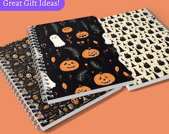 May include: Three spiral bound notebooks with Halloween themed designs. The first notebook has a black background with orange pumpkins, white ghosts, and black leaves. The second notebook has a black background with orange pumpkins and black leaves. The third notebook has a yellow background with black cats wearing witch hats.