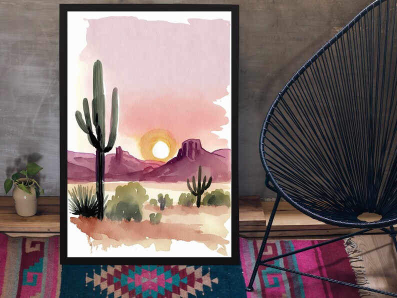 K&ouml;nnte beinhalten: Aquarellmalerei einer W&uuml;stenlandschaft mit einem Sonnenuntergang im Hintergrund. Das Gem&auml;lde zeigt einen gro&szlig;en Saguaro-Kaktus im Vordergrund, mit kleineren Kakteen und B&uuml;schen in der Ferne. Der Himmel ist in leuchtendem Rosa und Orange gehalten, mit einer strahlend gelben Sonne, die hinter den Bergen untergeht.
