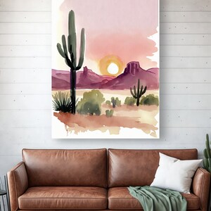 K&ouml;nnte beinhalten: Aquarellmalerei einer W&uuml;stenlandschaft mit einem gro&szlig;en Saguaro-Kaktus im Vordergrund, Bergen im Hintergrund und einer untergehenden Sonne.