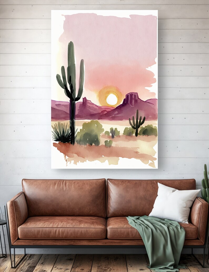 K&ouml;nnte beinhalten: Aquarellmalerei einer W&uuml;stenlandschaft mit einem gro&szlig;en Saguaro-Kaktus im Vordergrund, Bergen im Hintergrund und einer untergehenden Sonne.