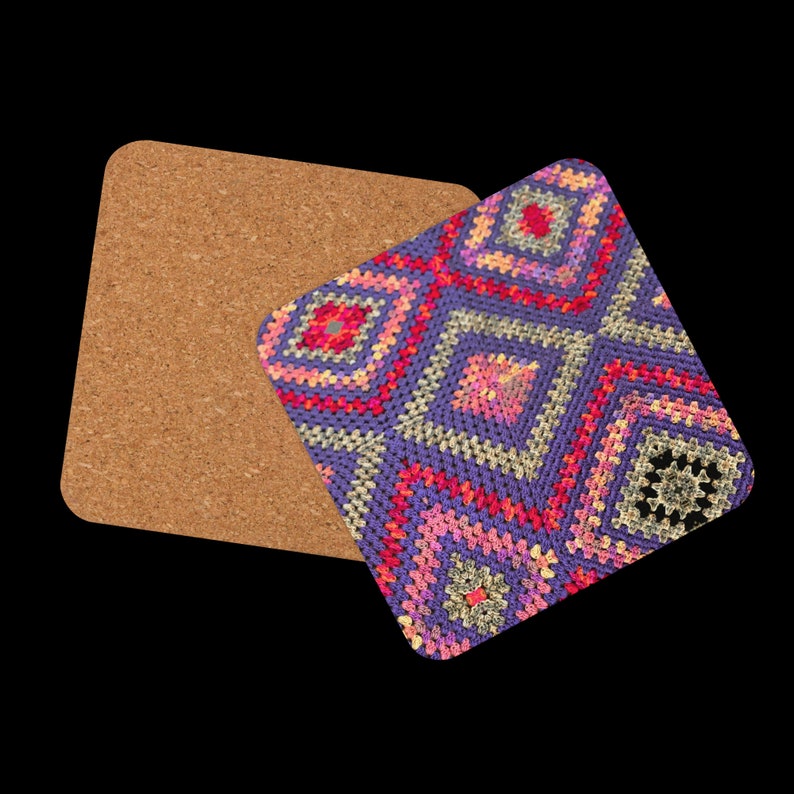 以下が含まれることがあります： 紫、ピンク、赤、黄色の色合いの、カラフルな幾何学模様のかぎ針編みデザインの正方形コルクコースター。 コースターは、無地のコルクコースターの隣に配置されています。 背景は黒です。