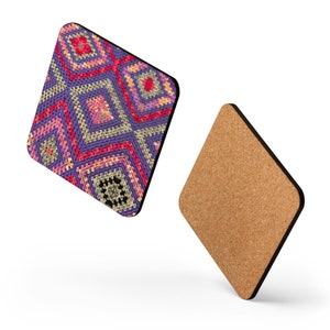 May include: Two diamond-shaped coasters. One coaster features a colorful, geometric pattern in shades of purple, pink, red, and cream. The other coaster has a cork backing. The coasters are designed to protect surfaces from drink rings.
