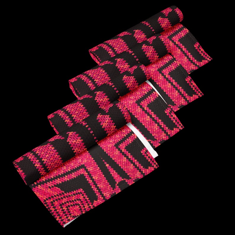 May include: Rolled fabric with a geometric pattern in pink and orange hues on a black backdrop. The design features repeating squares and angular shapes, giving a textured look. The fabric is likely for home decor, with measurements in centimetres.