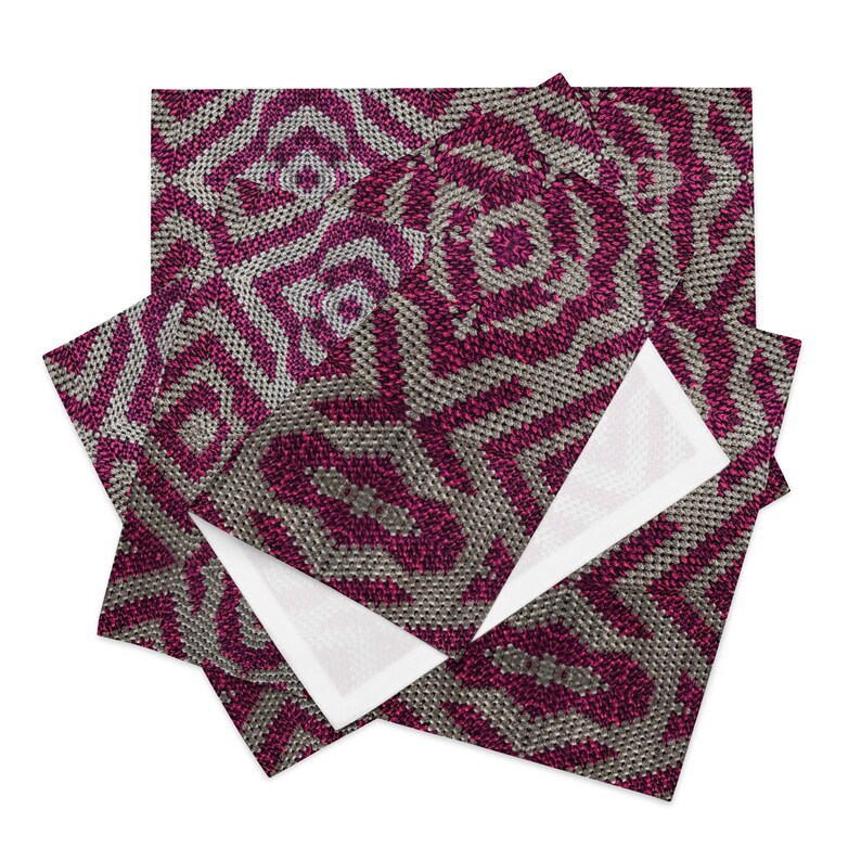 Pode incluir: Uma pilha de guardanapos de tecido decorativos com um padr&atilde;o geom&eacute;trico repetitivo em tons de cinza e magenta. O design apresenta formas de diamante conc&ecirc;ntricas, criando uma apar&ecirc;ncia texturizada e tecida. Os guardanapos est&atilde;o dobrados, revelando um interior branco.